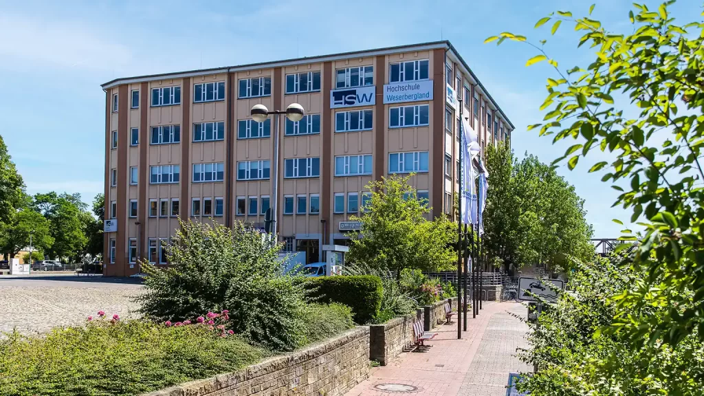 Das Gebäude der HSW von der Weserpromenade aus zu sehen mit Aufschrift und Logo