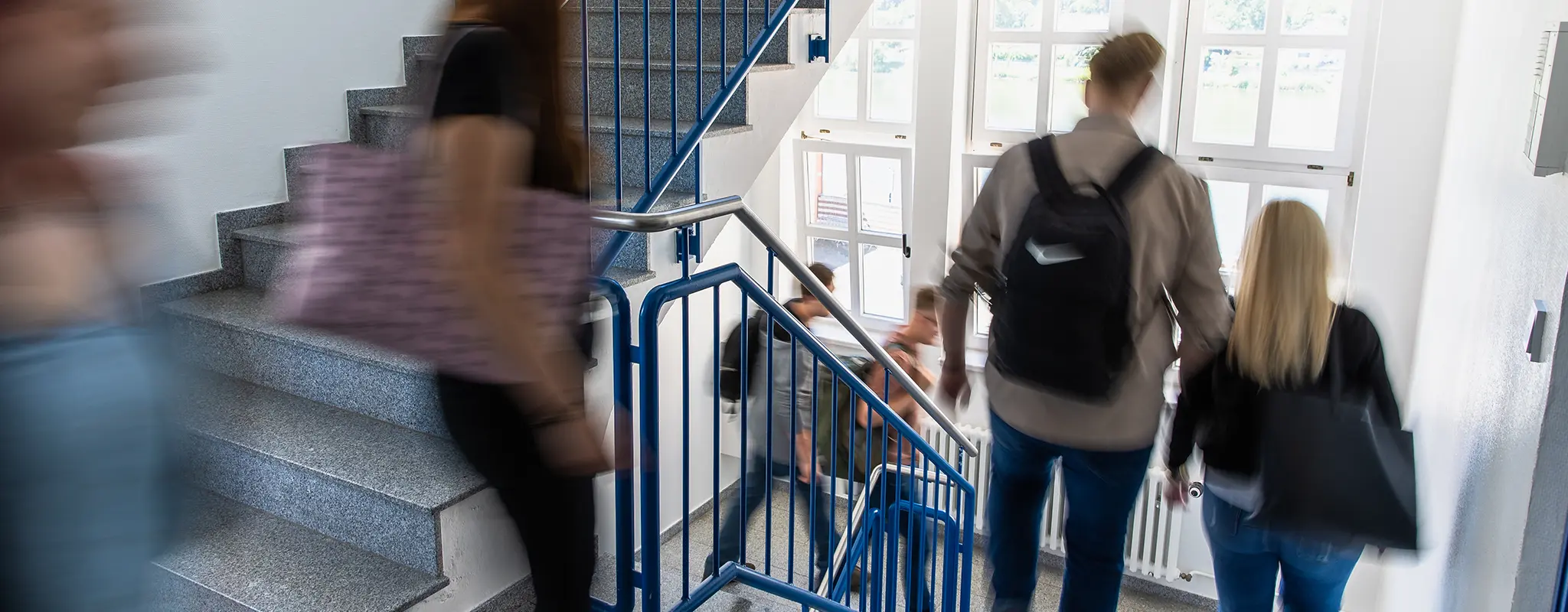 Studierende gehen durch ein Treppenhaus