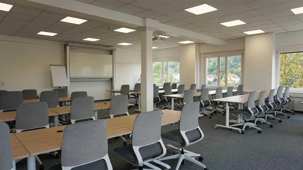 Seminarraum mit Stuhlreihen und Blick nach vorne zum Whiteboard und Flipchart