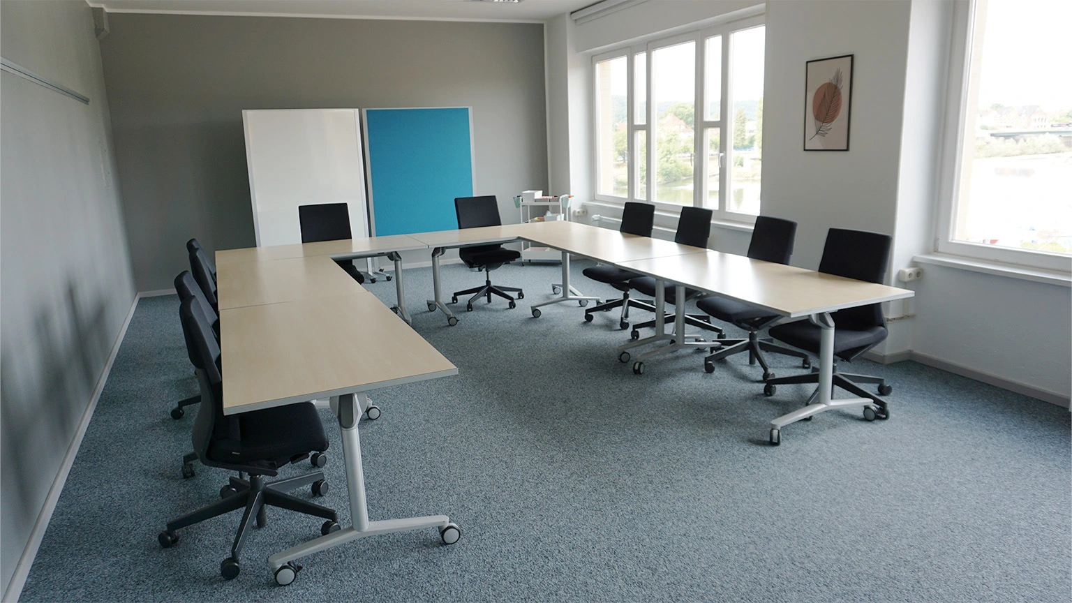 Seminarraum in U-Form bestuhlt mit Blick nach hinten, wo zwei Pinnwände stehen