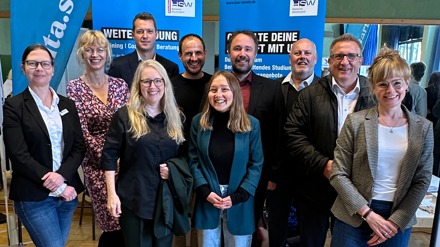 Projektteam zedita.startup in zwei Reihen vor blau schwarzen Rollups